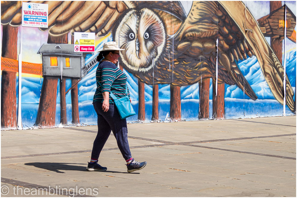 Woman walking in front of street art